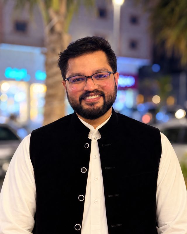 Faris smiling outdoors in the evening